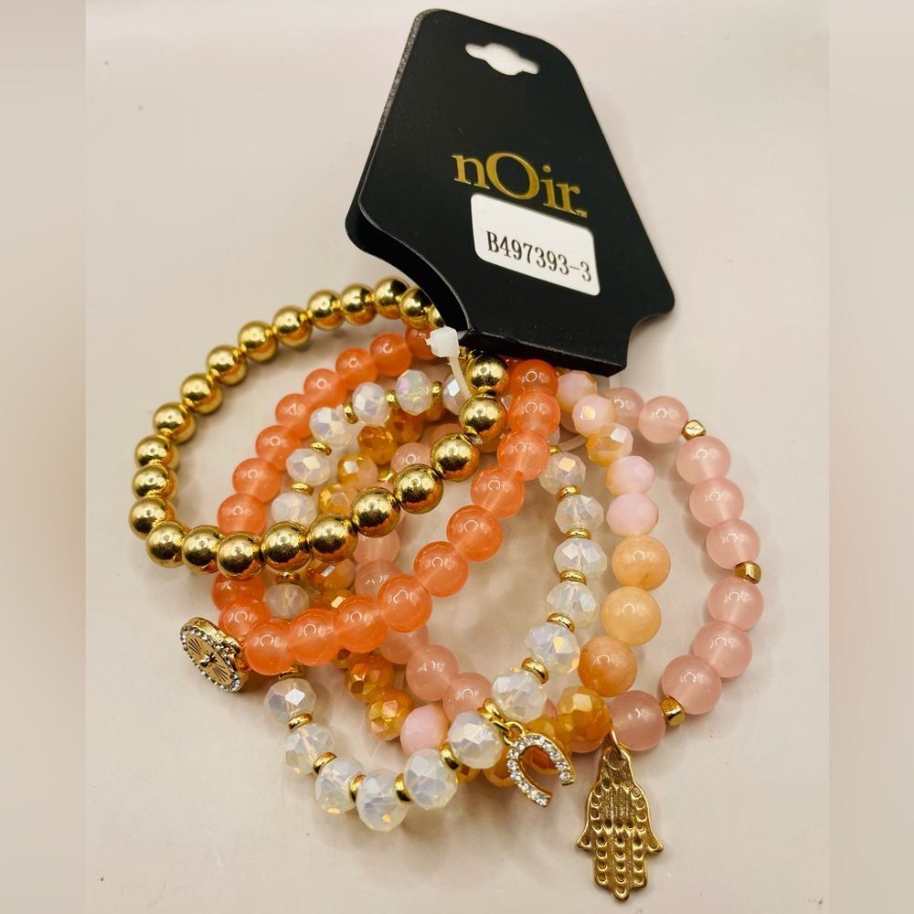 nOir 5 piece good luck stretchy bracelet set. Peach, gold, white beads. Charms